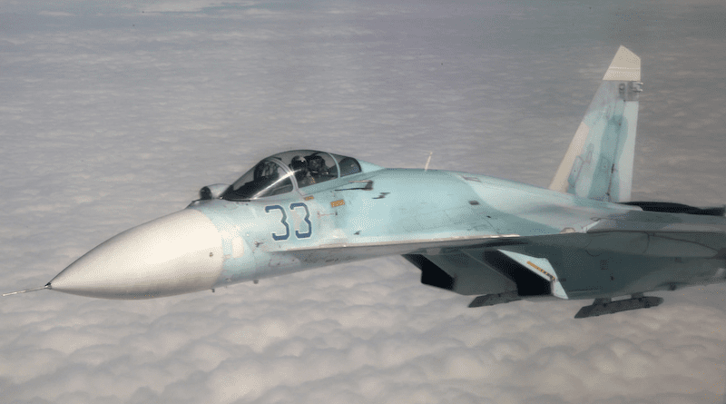 A Russian Su-27 fighter flies above a cluster of clouds. Photo Credit: Canadian armed forces, DOD