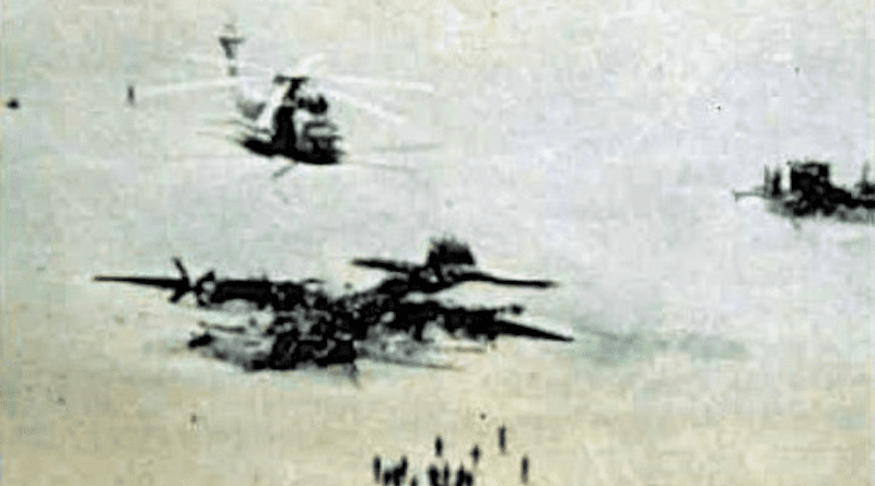A photo of the "Desert One" landing site, a piece of desert in Iran used by U.S. forces as a refueling point in an attempt to rescue U.S. hostages in Iran. On 24 April 1980 a U.S. Navy Sikorsky RH-53D Sea Stallion (BuNo 158760, visible at right) collided with a U.S. Air Force Lockheed EC-130E Hercules (s/n 62-1809, wrecked in the foreground) during refueling after the mission was aborted. Both aircraft were destroyed, eight crewmen died. In the background is one of the five intact, but abandoned RH-53Ds. Photo Credit: U.S. military, Wikipedia Commons
