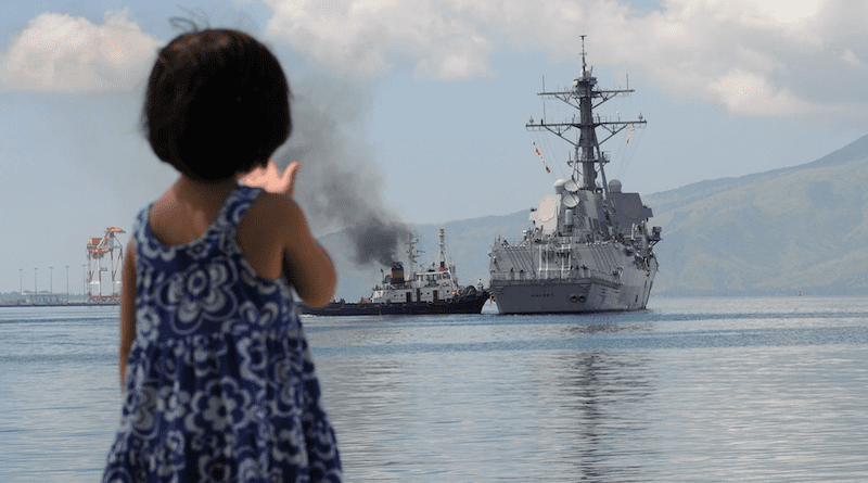 A Filipino child waves as the guided-missile destroyer USS Halsey gets underway after participating in Cooperation Afloat Readiness and Training Philippines. Photo Credit: Petty Officer 1st Class Thomas Brennan, US Navy