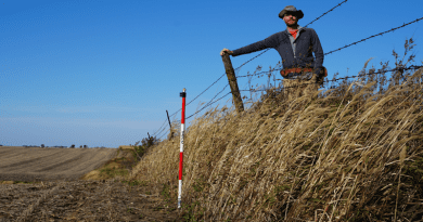 UMass Amherst geosciences professor Isaac Larsen standing on the erosional escarpment at Stinson Prairie, Iowa. CREDIT: UMass Amherst