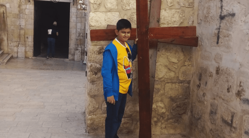 The author Apratim Acharyya standing in front of a cross on the Via Dolorosa in Jerusalem. (photo provided by family)