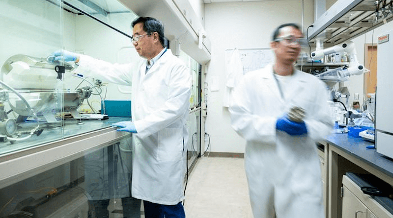 Senior chemist Di-Jia Liu inspects catalyst sample inside tube furnace after heat treatment while postdoc Chenzhao Li carries a pressure reactor for catalyst synthesis. CREDIT: Image by Argonne National Laboratory.