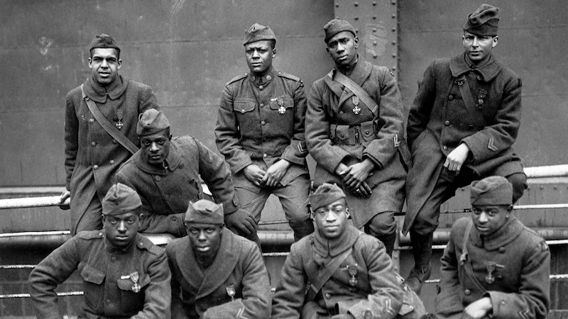 On USS Stockholm, nine Soldiers of 369th Infantry Regiment, awarded French government’s Croix de Guerre for gallantry in action, pose for photo while awaiting disembarkation in New York City, February 12, 1919; left to right, front row, Private Ed Williams, Private Herbert Taylor, Private Leon E. Fraiter, Private Ralph Hawkins; back row, Sergeant Henry David Primas, Sr., Sergeant Daniel W. Storms, Jr., Private Joe Williams, Private Alfred S. Manley, and Corporal Tyler W. Taylor (U.S. National Archives and Records Administration)