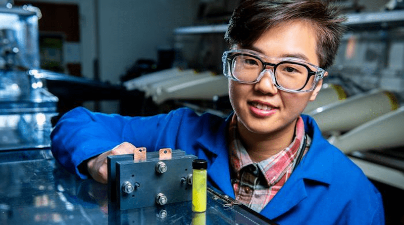 Flow battery researcher Ruozhu Feng poses with ingredients for a long-lasting grid energy battery CREDIT: Andrea Starr | Pacific Northwest National Laboratory