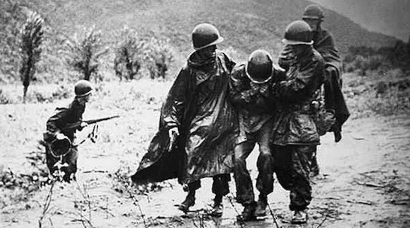 Army Chaplain (Capt.) Emil Kapaun (right) and Army Capt. Jerome A. Dolan, 1st Cavalry Division, carry an exhausted soldier off the battlefield in Korea, early in the war. Photo Credit: US Army