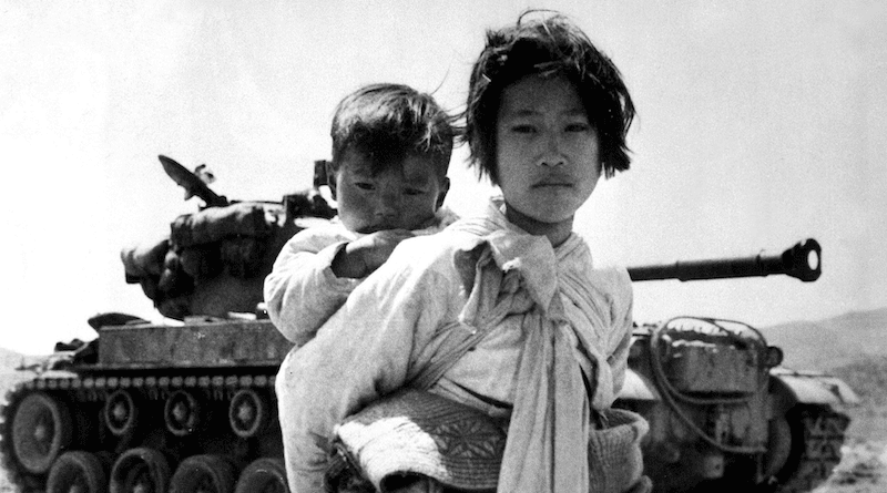 A young Korean girl carries her brother past a stalled M-46 tank, at Haengju, Korea. Photo Credit: Maj. R.V. Spencer, UAF (Navy). U.S. Army Korea, Wikimedia Commons