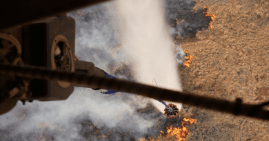 A military aircraft participates in an aerial water bucket drop to fight a wildfire on the island of Maui, Hawaii, August 9, 2023. Photo Credit: Air Force Master Sgt. Andrew Jackson
