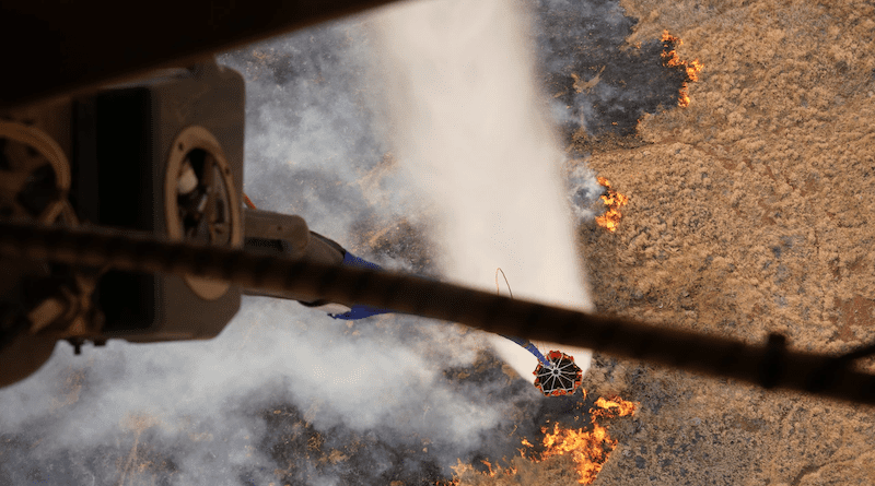 A military aircraft participates in an aerial water bucket drop to fight a wildfire on the island of Maui, Hawaii, August 9, 2023. Photo Credit: Air Force Master Sgt. Andrew Jackson