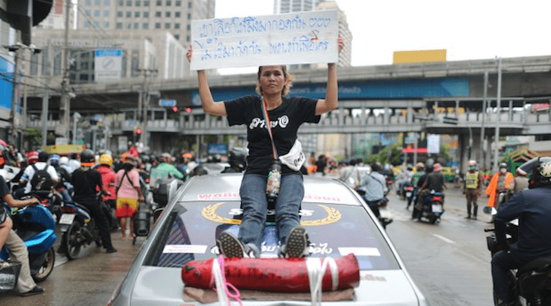 A supporter of the Move Forward Party brandishes a placard that reads, “You are elected to hug, not bite each other. Pheu Thai [For Thai] is for whom?” after the Pheu Thai Party ousted the Move Forward from a new coalition on Aug. 2, 2023. Photo Credit: Nava Sangthong/BenarNews
