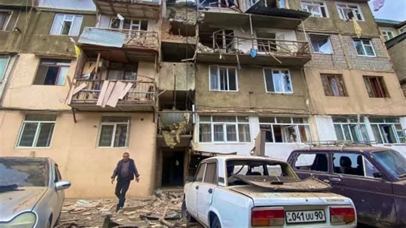 A man leaves a bombed apartment building in Nagorno-Karabakh. Photo Credit: Tasnim News Agency
