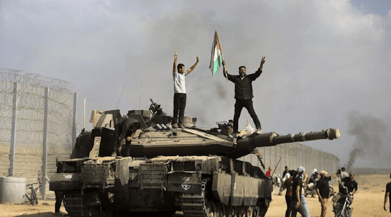 Palestinians on destroyed Israeli tank. Photo Credit: Mehr News Agency