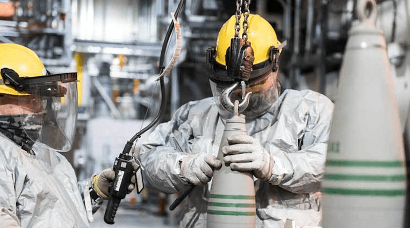Operators lift a 155 mm projectile containing VX nerve agent to place it in a tray for destruction at the Blue Grass Chemical Agent-Destruction Pilot Plant, Ky. Photo Credit: James Campbell, DOD