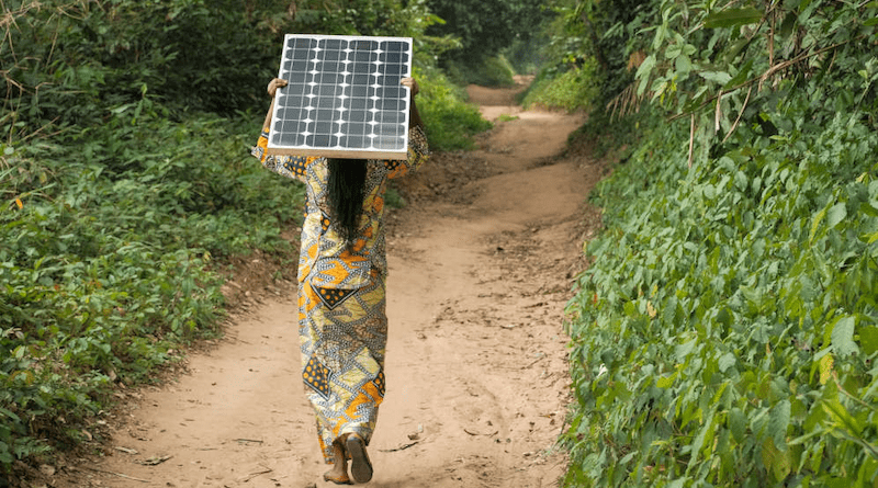 Woman carrying a solar pannel near Yangambi, DRC. Solar could be dominant power source by 2050, researchers have said. Copyright: Axel Fassio/CIFOR, (CC BY-NC-ND 2.0 DEED).