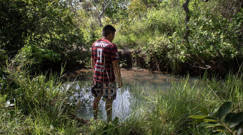 Daniel Nagelo stands near the creek where he learned to swim as a child. Back then, the water in the creek was high enough for him to swim, but now it barely reaches his waist. Image by Amanda Magnani for Mongabay.