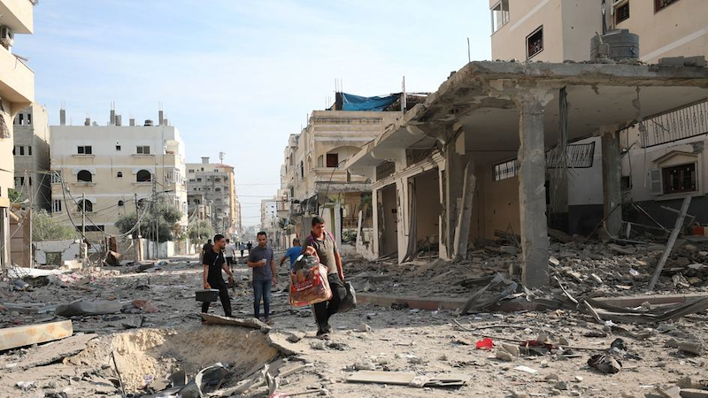 Men walk through the destroyed streets of Gaza. Photo Credit: WHO