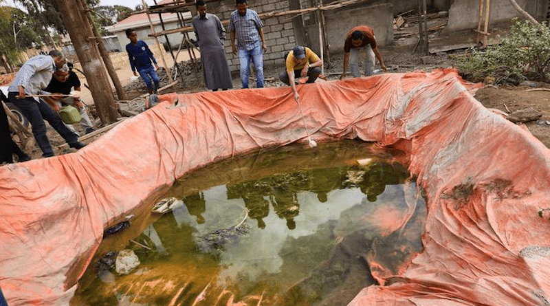 Sampling for mosquito larva in the water of a manmade pit at a construction site made of simple earthern walls covered in plastic sheeting. CREDIT: Photo by Gonzalo Vazquez-Prokopec