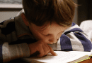 A young boy reading. Photo Credit: Michał Parzuchowski - Unsplash