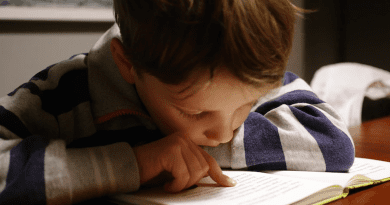 A young boy reading. Photo Credit: Michał Parzuchowski - Unsplash