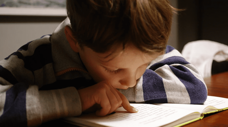 A young boy reading. Photo Credit: Michał Parzuchowski - Unsplash