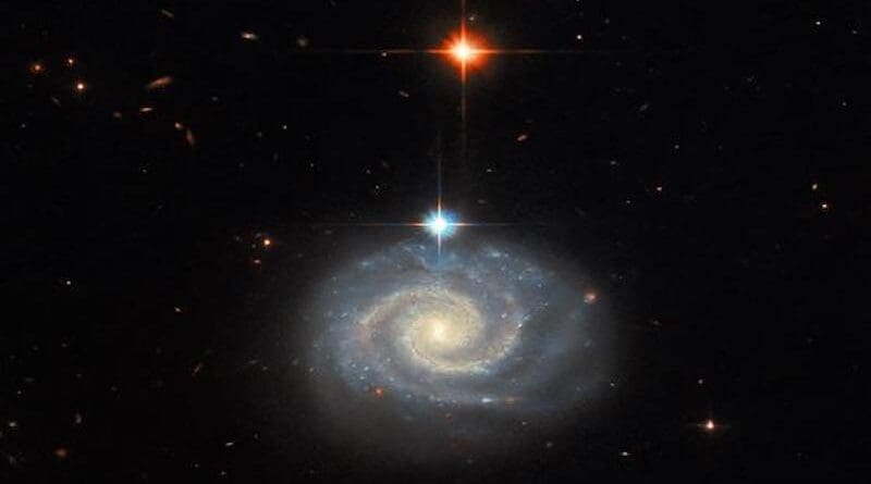 This NASA Hubble Space Telescope image features a bright spiral galaxy known as MCG-01-24-014, which is located about 275 million light-years from Earth. CREDIT: ESA/Hubble & NASA, C. Kilpatrick