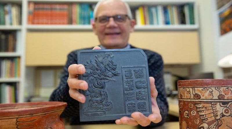UNIVERSITY OF CINCINNATI PROFESSOR DAVID LENTZ HOLDS UP A REPRODUCTION TILE FEATURING ANCIENT MAYA GLYPHS. RESEARCHERS DISCOVERED EVIDENCE OF CEREMONIAL OFFERINGS AT THE SITE OF AN ANCIENT MAYA BALLCOURT IN YAXNOHCAH, MEXICO. CREDIT: ANDREW HIGLEY