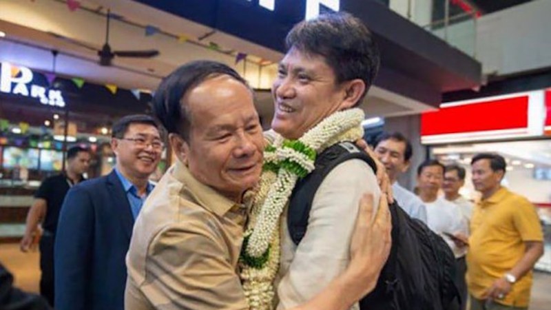 Kry Masphal, right, the former director of Cambodia’s Department of Wildlife and Biodiversity, is embraced by Nao Thuok, secretary of state for Cambodia’s Ministry of Agriculture, Forests and Fisheries, after Kry’s arrival in Cambodia in March 2024. (Cambodian government)