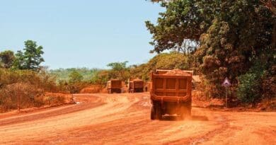 Trucks transporting bauxite along a mining hauling road in Guinea. CREDIT: Genevieve Campbell