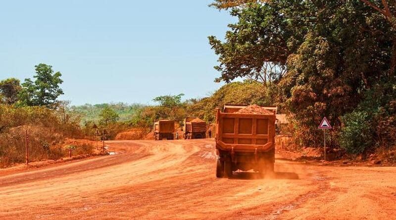 Trucks transporting bauxite along a mining hauling road in Guinea. CREDIT: Genevieve Campbell
