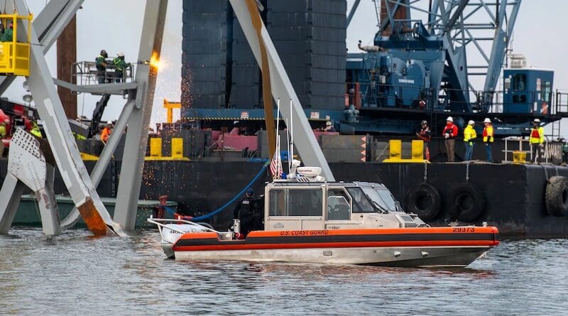 A Coast Guard Station Crisfield 29-foot response boat-small observes as highly trained demolition crews begin cutting the top portion of the north side of the collapsed Francis Scott Key Bridge into smaller sections for safe removal by crane in the Patapsco River in Baltimore, March 30, 2024. Salvage teams use an exothermic cutting torch to systematically separate sections of the steel bridge, which will be taken to a disposal site. Photo Credit: Coast Guard Petty Officer 3rd Class Kimberly Reave