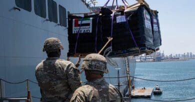 U.S. Army soldiers with the 7th Transportation Brigade (Expeditionary) use a rope to stabilize humanitarian aid while it is lifted by a crane aboard the MV Roy P. Benavidez at the Port of Ashdod, Israel. Photo Credit: Army Staff Sgt. Malcolm Cohens-Ashley