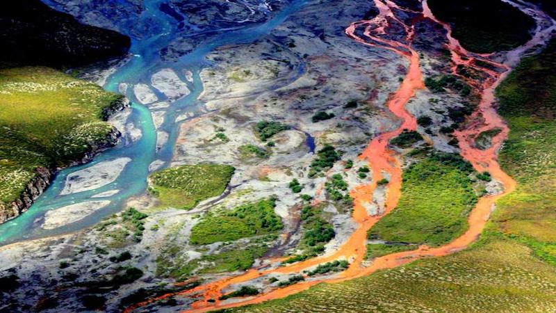 An aerial view of the rust-colored Kutuk River in Gates of the Arctic National Park in Alaska. Thawing permafrost is exposing minerals to weathering, increasing the acidity of the water, which releases metals like iron, zinc and copper. CREDIT: Ken Hill / National Park Service