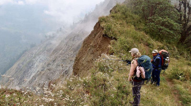 Tourists in October 2023 looking at mountain slopes affected by a slandslide along the Kanchenjunga Trek in Nepal . Most natural landslides are triggered by earthquakes or rainfall, or a combination of both. Copyright: Bruno Rijsman (CC BY 2.0). This photo has been cropped.