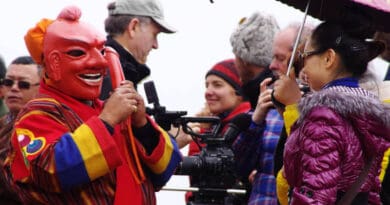 A local artist entertaining tourists and a filming crew in Bhutan. According to the UN World Tourism Organization (UNWTO), the global tourist industry was among the hardest hit by the COVID-19 pandemic. Copyright: Courtesy of Tourism Council of Bhutan (CC BY-ND 2.0).