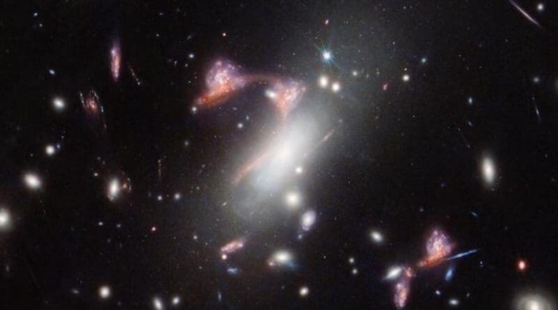 The galaxy cluster MACS-J0417.5-1154 is so massive it is warping the fabric of space-time and distorting the appearance of galaxies behind it, an effect known as gravitational lensing. This natural phenomenon magnifies distant galaxies and can also make them appear in an image multiple times, as NASA’s James Webb Space Telescope saw here. Two distant, interacting galaxies — a face-on spiral and a dusty red galaxy seen from the side — appear multiple times, tracing a familiar shape across the sky. Active star formation, and the face-on galaxy’s remarkably intact spiral shape, indicate that these galaxies’ interaction is just beginning. CREDIT: NASA, ESA, CSA, STScI, V. Estrada-Carpenter (Saint Mary's University).