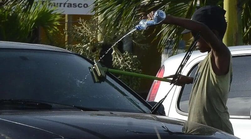 A young boy working in the street cleaning car windshields. Photo Credit: Valter Campanato, Agencia Brasil