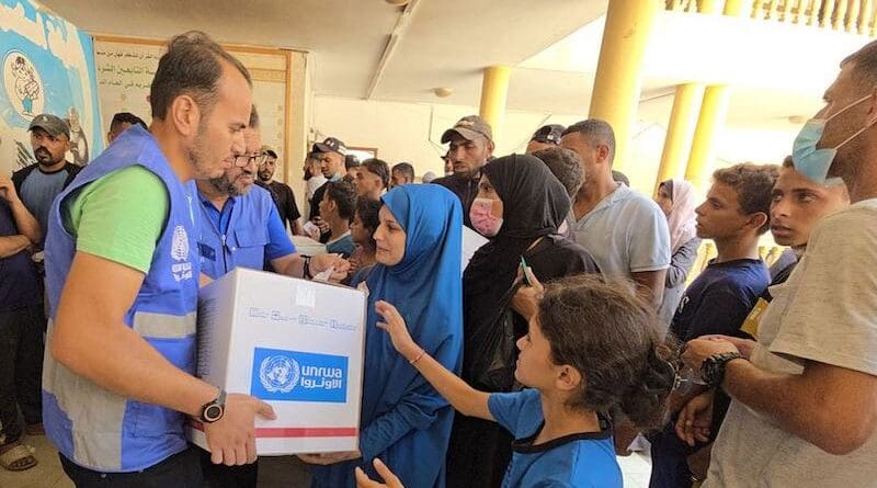 An UNRWA staff member distributing aid to affected civilians in Gaza. Photo Credit: UNRWA