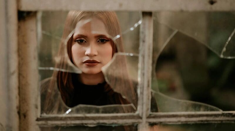 glass house window broken woman rock