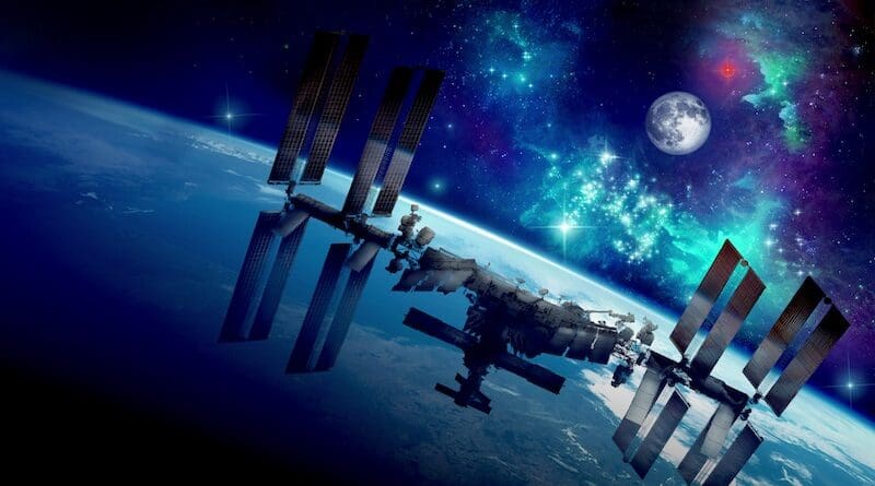 An artist’s concept of the International Space Station orbiting Earth. In the distance is the Moon, and a red star representing Mars. Credit: NASA