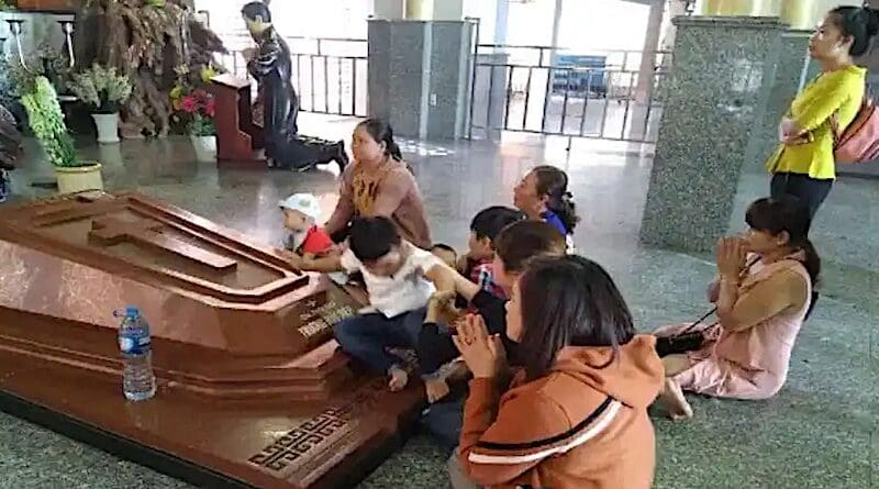 Vietnamese pilgrims pray by the tomb of Servant of God, Father Francis Xavier Truong Buu Diep, at Tac Say Church in Bac Lieu province. (UCA News photo)