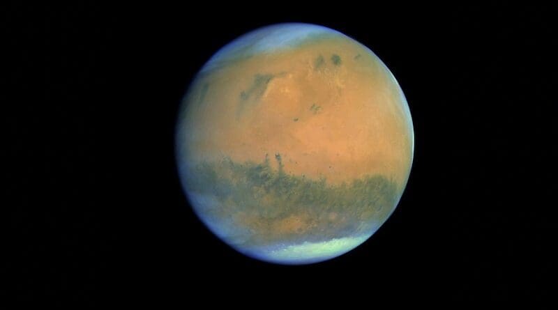The full disc of Mars is seen with the polar ice caps slightly off centre to the top left and bottom right. Clouds wrap around the planet’s curved horizons. Dark surface markings are clearly seen against the characteristic red tones of the dusty martian surface. CREDIT: ESA & MPS for OSIRIS Team MPS/UPD/LAM/IAA/RSSD/INTA/UPM/DASP/IDA, 2007