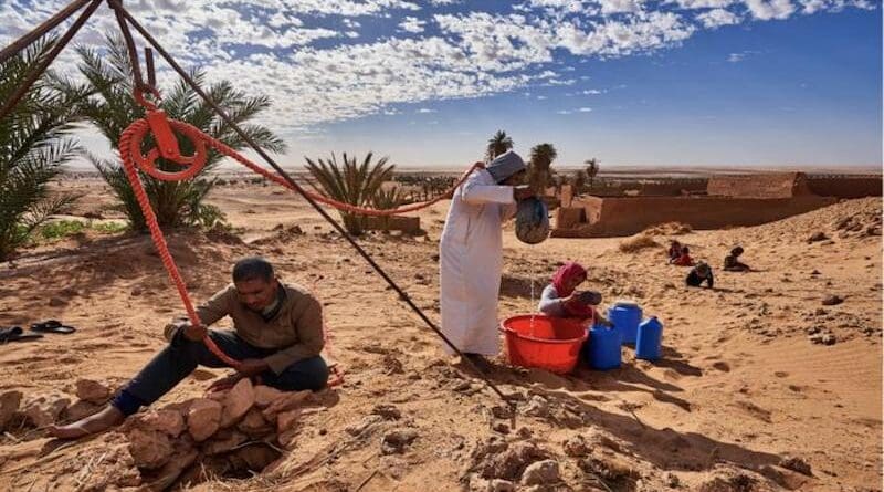 In the heart of the desert, a group of people work together to extract water from a traditional well using a manual pulley system. CREDIT: Abdallah Khalili / UNCCD